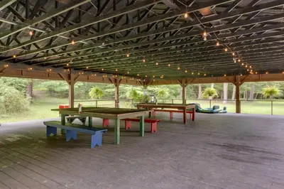 a group of picnic tables under a pavilion with lights at Deluxe Cabin D at Elk Creek Escape! Pets Welcome in Hillsgrove