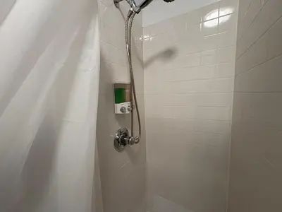 a shower with a shower curtain in a bathroom at The Midtown Ninth Manhattan Times Square in New York