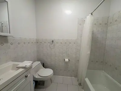 a white bathroom with a toilet and a bath tub at The Midtown Ninth Manhattan Times Square in New York