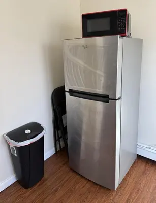 a microwave on top of a refrigerator next to a trash can at Private one-bedroom and one-bathroom apartment, private street entrance in convenient area, MetLife Stadium FIFA World Cup 35 minutes away in Perth Amboy