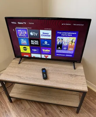 a television on a wooden stand with a remote control at Private one-bedroom and one-bathroom apartment, private street entrance in convenient area, MetLife Stadium FIFA World Cup 35 minutes away in Perth Amboy