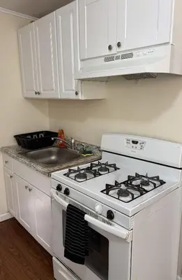 a kitchen with a white stove and a sink at Private one-bedroom and one-bathroom apartment, private street entrance in convenient area, MetLife Stadium FIFA World Cup 35 minutes away in Perth Amboy