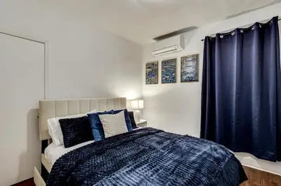 a bedroom with a bed and a blue curtain at Walk to Public Transit! Pet-Friendly Lodi Apt in Lodi