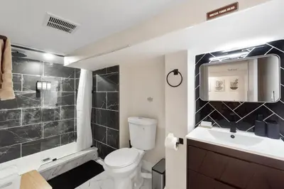 a bathroom with a toilet and a sink and a shower at Cozy 1BR level apartment w patio & workstation in Jersey City