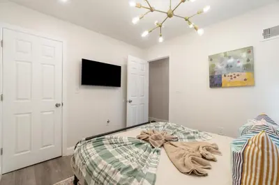 a bedroom with a bed and a tv on the wall at Cozy 1BR level apartment w patio & workstation in Jersey City
