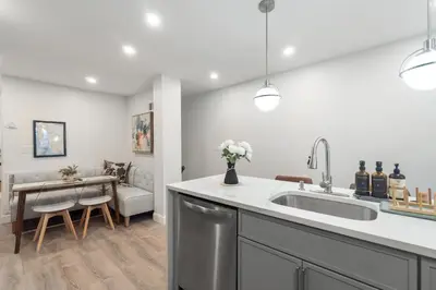 a kitchen with a sink and a living room at Cozy 1BR level apartment w patio & workstation in Jersey City
