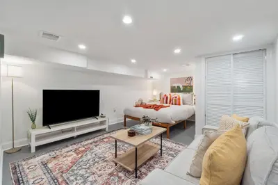 a living room with a couch and a tv and a bed at Holiday Home Brownstone City Stay 5BEDS, Private Dual Units in Jersey City