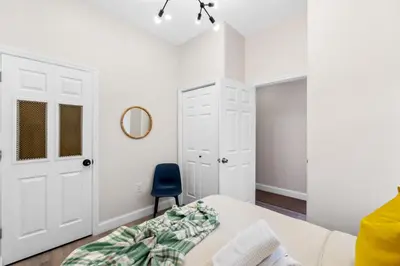 a bedroom with a bed and a blue chair at Holiday Home Brownstone City Stay 5BEDS, Private Dual Units in Jersey City