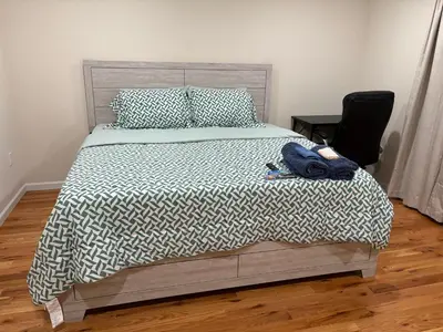 a bedroom with a bed with a black and white comforter at Luxury Apartment near Airport in Newark