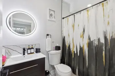 a bathroom with a toilet and a sink and a mirror at Luxe Oasis with Gym - Near Stadium & Hospital with Rooftop in Philadelphia
