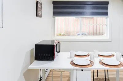 a white table with a microwave and plates on it at Cozy and Convenient Studio with 3 beds 10 Minutes to NYC in Union City