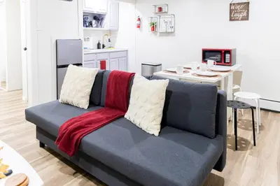 a living room with a couch and a kitchen at Cozy and Convenient Studio with 3 beds 10 Minutes to NYC in Union City