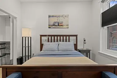 a bed sitting in a room with a window at City Living without Compromise Full-Size 1BR in Philadelphia