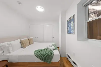 a white bedroom with a bed and a window at One Hamilton Essentials - 3 Bedroom 2 Bathroom Apt Mins to NYC in Jersey City