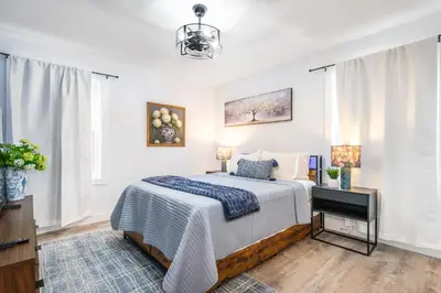 a bedroom with a bed with a blue and white blanket at Luxury Apartment in Irvington in Irvington