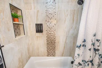 a bathroom with a shower with a tub and a sink at Luxury Apartment in Irvington in Irvington