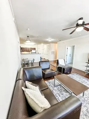 a living room with a leather couch and chairs at The Waverly in Newark