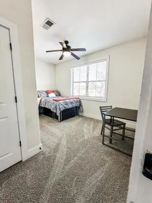 a bedroom with a bed and a ceiling fan at The Waverly in Newark