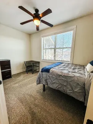 a bedroom with a bed and a ceiling fan at The Waverly in Newark