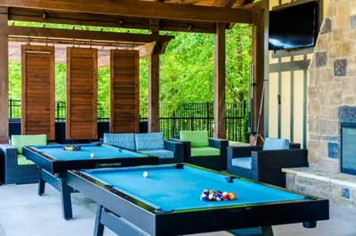 a patio with two pool tables and chairs at The Waverly in Newark