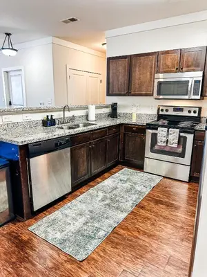 a kitchen with stainless steel appliances and wooden cabinets at The Waverly in Newark