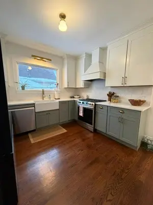 a kitchen with white cabinets and a large window at The Grand Colonial Retreat Spacious 5BR Home near MetLife Stadium in Kearny