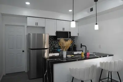 a kitchen with white cabinets and a stainless steel refrigerator at Prime Oasis,1 mi to Temple U,Washer and Dryer,Free Snacks in Philadelphia
