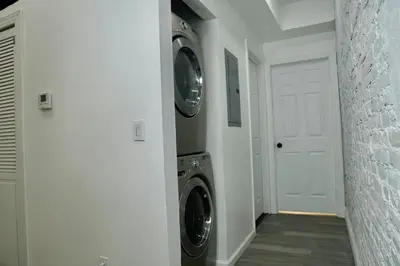 a laundry room with two washing machines and a door at Prime Oasis,1 mi to Temple U,Washer and Dryer,Free Snacks in Philadelphia