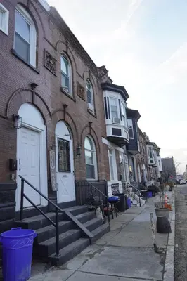 a brick building with a white door on a street at Prime Oasis,1 mi to Temple U,Washer and Dryer,Free Snacks in Philadelphia