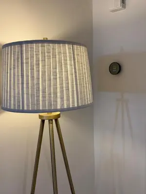 a lamp with a striped shade on a stool at CASA 311 ! Welcome Home Private Parking Included in Jersey City
