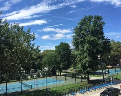 a tennis court in a park with people on it at CASA 311 ! Welcome Home Private Parking Included in Jersey City