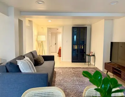 a living room with a blue couch and a tv at CASA 311 ! Welcome Home Private Parking Included in Jersey City