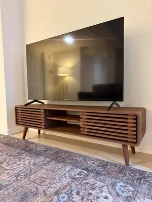 a large flat screen tv sitting on a entertainment center at CASA 311 ! Welcome Home Private Parking Included in Jersey City