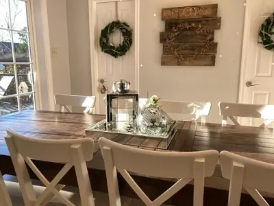 a dining room with a table and white chairs at Lux Home 5 min to Train and Airport