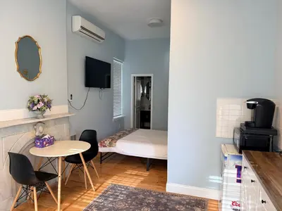 a small room with a bed and a table and chairs at Bright Private Apartment in University city near Drexel&UPenn in Philadelphia
