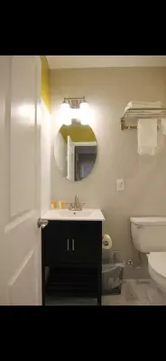 a bathroom with a sink and a mirror and a toilet at Bright Private Apartment in University city near Drexel&UPenn in Philadelphia