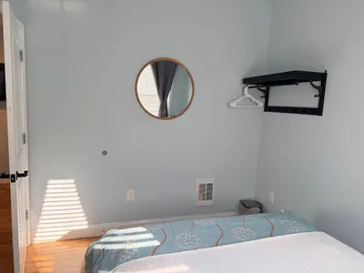 a bedroom with a bed and a mirror on the wall at Fresh&Quiet one bedroom Apartment in University City near Drexel&UPenn in Philadelphia