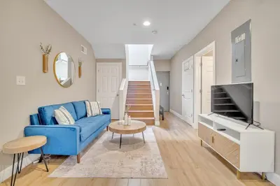 a living room with a blue couch and a tv at Huge 5 bedroom in Center City Philadelphia in Philadelphia