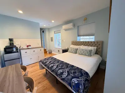 a bedroom with a large bed and a kitchen at Sunny&Cozy Apartment in University City near Drexel&UPenn in Philadelphia