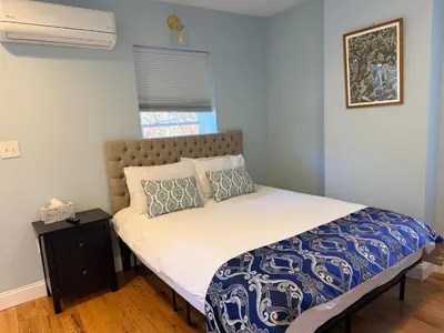 a bedroom with a bed with a blue and white comforter at Sunny&Cozy Apartment in University City near Drexel&UPenn in Philadelphia
