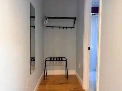 a hallway with a mirror and a chair in a room at Sunny&Cozy Apartment in University City near Drexel&UPenn in Philadelphia