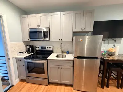 a kitchen with white cabinets and a stainless steel refrigerator at Super Cozy two bedrooms Apartment in University City near Drexel&UPenn in Philadelphia