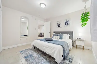 a white bedroom with a bed and a blue blanket at Cozy 3 bedroom in Center City Philadelphia in Philadelphia