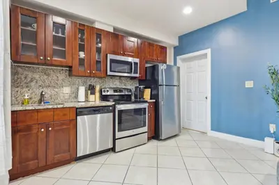 a kitchen with wooden cabinets and stainless steel appliances at Cozy 3 bedroom in Center City Philadelphia in Philadelphia