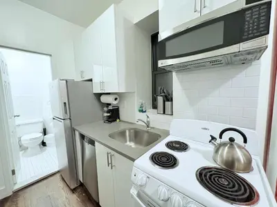 a white kitchen with a stove and a sink at The W50 Metropolitan in New York