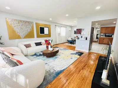 a living room with a white couch and a table at Lux NYC Stay 3Bed2Bath w parking in Jersey City