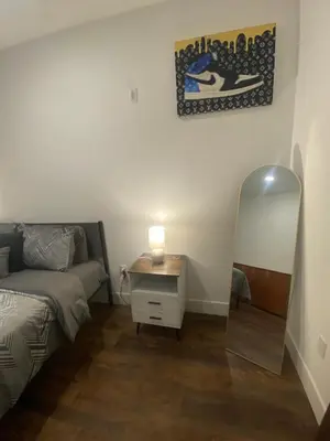 a bedroom with a bed and a mirror next to a dresser at Luxury Northern Liberties Living in Philadelphia