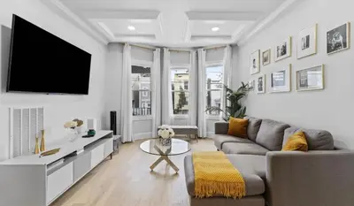 a living room with a couch and a tv at Chic 3BR-4BD-3Bath Oasis with Backyard Near NYC in Jersey City