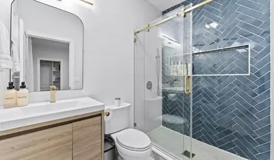 a bathroom with a toilet and a glass shower at Chic 3BR-4BD-3Bath Oasis with Backyard Near NYC in Jersey City