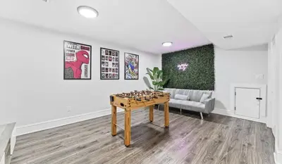 a living room with a table and a couch at Chic 3BR-4BD-3Bath Oasis with Backyard Near NYC in Jersey City